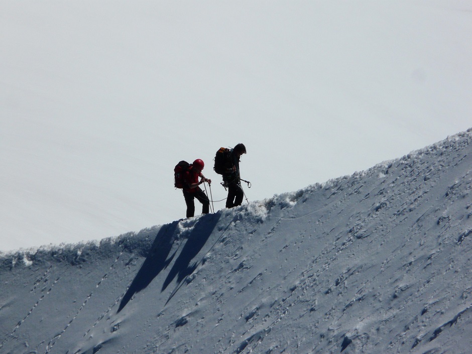 climbers make their ascent up a snowy mountain