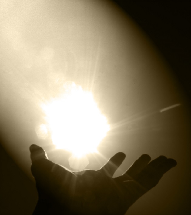 a hand reaches for and cups the sun