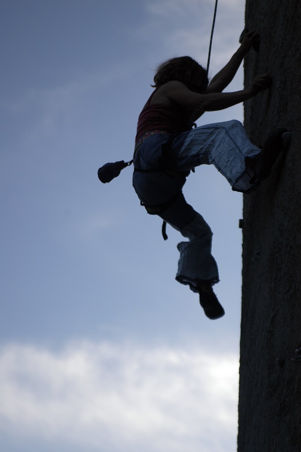 a woman climbs a vertical face