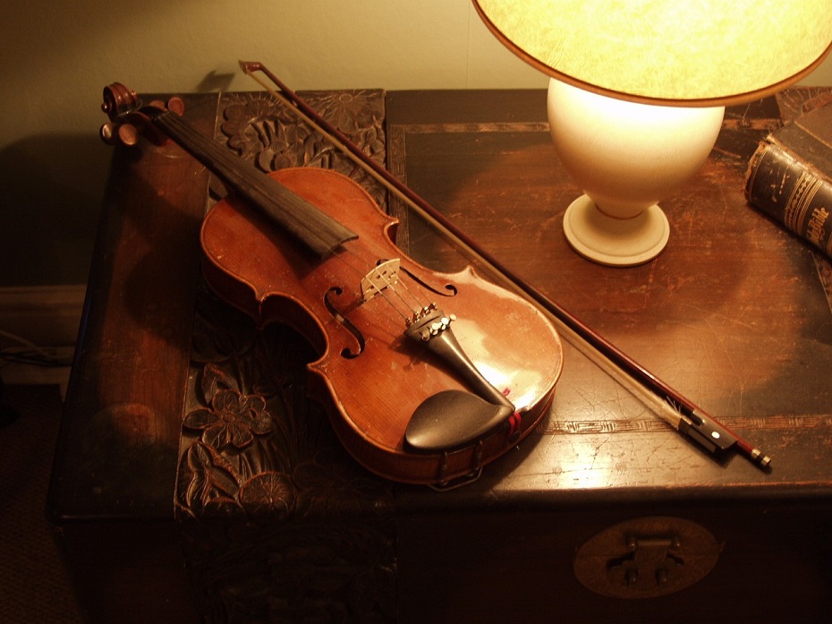 a violin rests on a carved end table