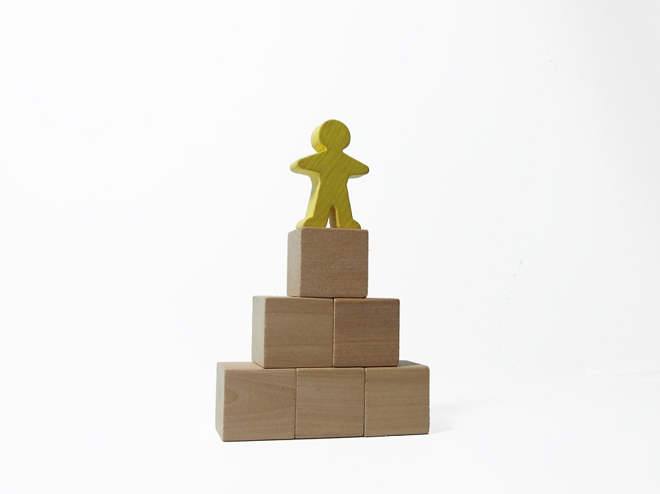 a yellow block man stands on top of a tower of blocks